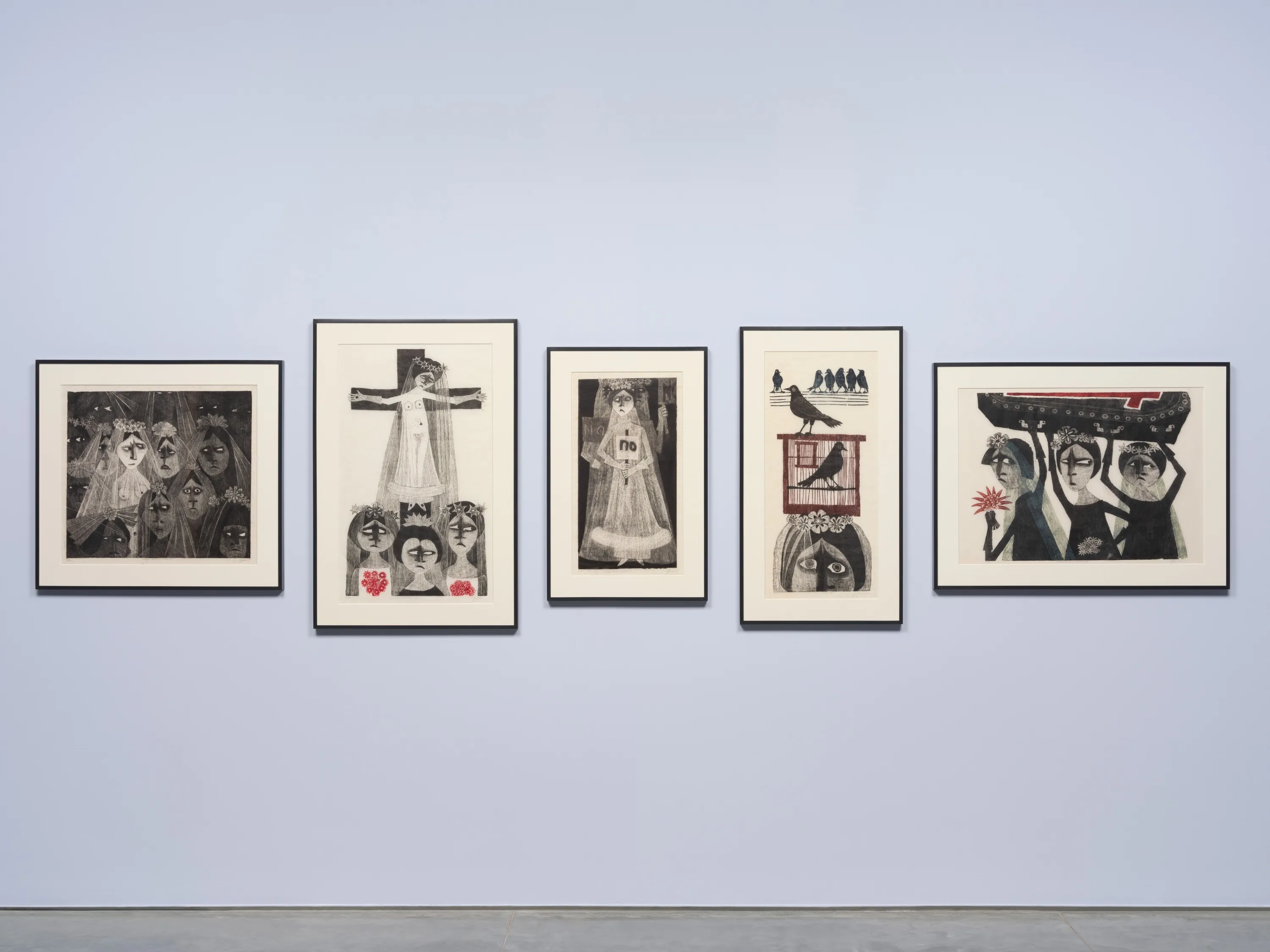 Five framed woodcuts installed side by side on a light lavender wall.